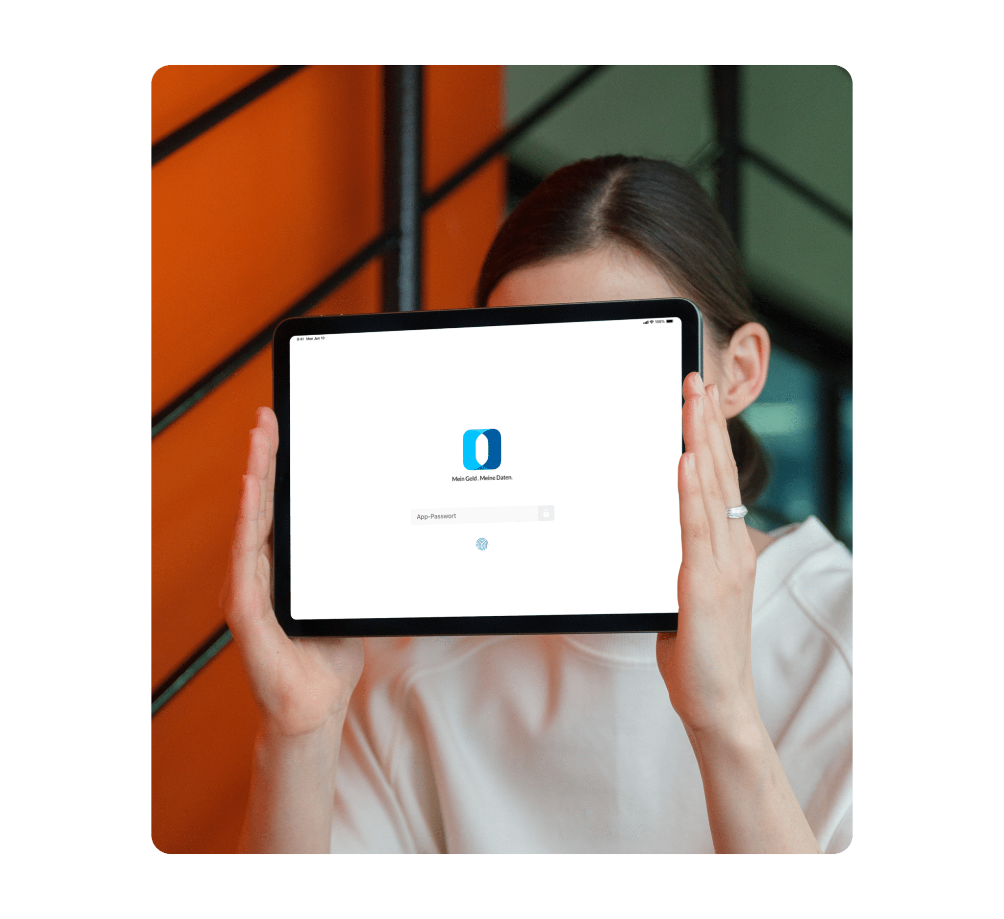 Frau hält Tablet mit Outbank-Login-Bildschirm vor ihr Gesicht.